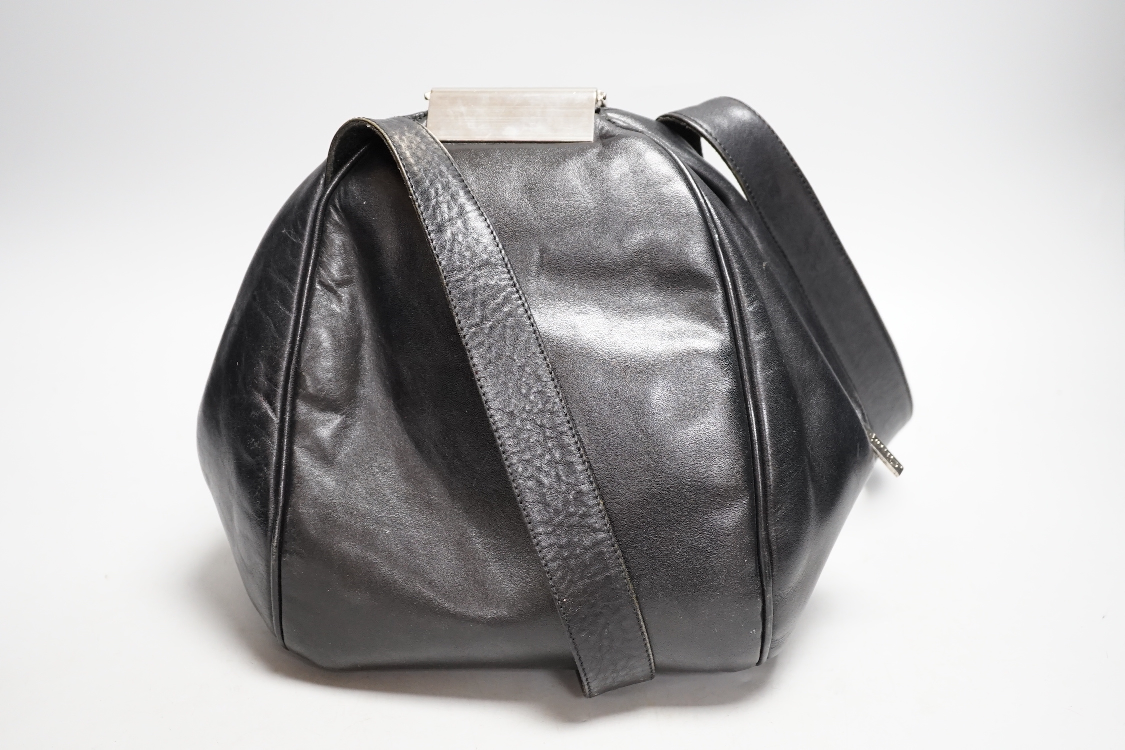 A Nina Ricci black leather shoulder bag with large metal clasp, engraved Nina Ricci, circa 1970's, approx. 23cm high